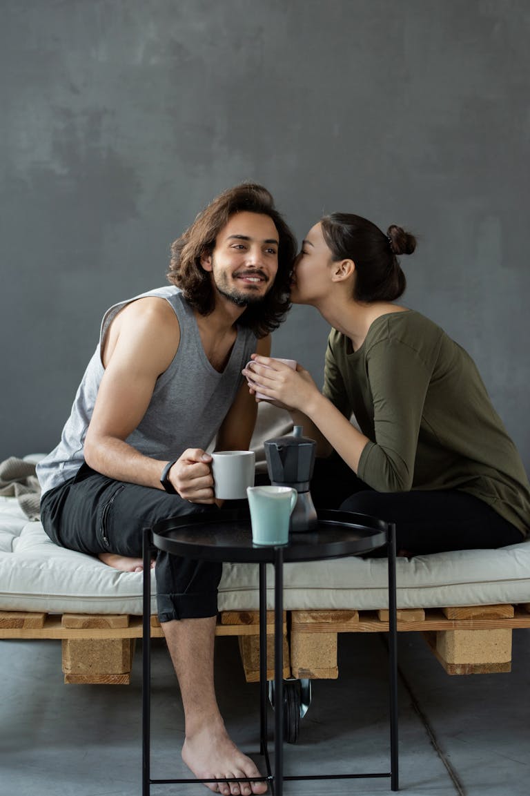 Young couple enjoying a cozy morning with coffee, creating intimate moments indoors.